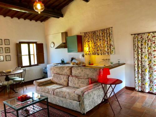 a living room with a couch and a kitchen at Tenuta di Corsano in Monteroni dʼArbia