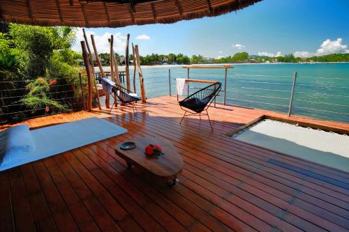 a wooden deck with a hammock and a swing at L'heure Bleue in Ambatoloaka