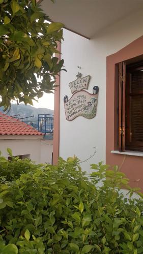 a sign hanging on the side of a building at Green Hill Studios & Apartments in Kokkari