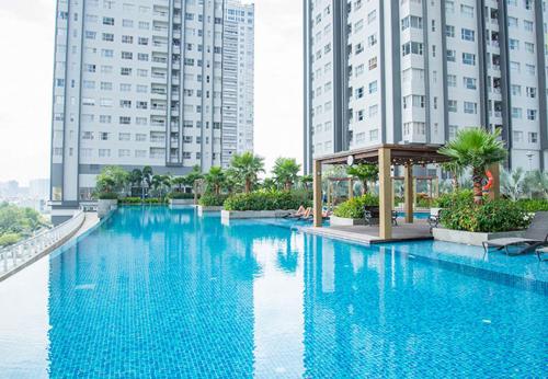 a large blue swimming pool in front of tall buildings at Sunrise City - 5 star in Ho Chi Minh City