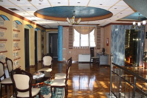 a room with chairs and a table and a ceiling at Hotel Bar Restaurant America in Kukës