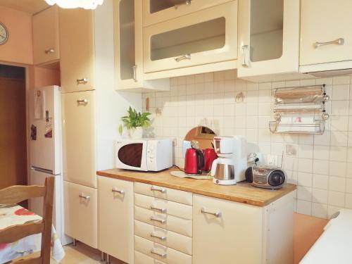uma cozinha com armários brancos e um balcão com um micro-ondas em Chez Violette em Destry