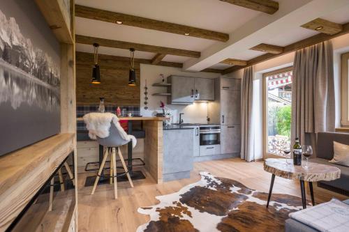 a kitchen with a table and a counter in a room at Landhaus BergMoment - adults only in Ellmau