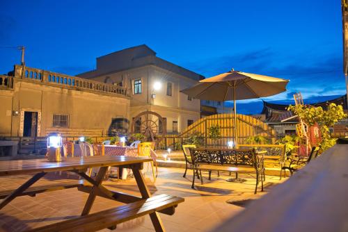 un patio con tavoli, sedie e un ombrellone di Home Inn a Jincheng