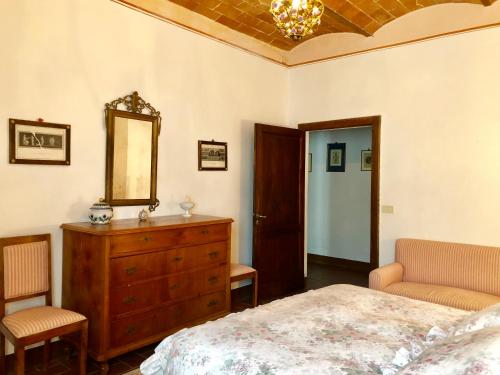 1 dormitorio con cama, tocador y espejo en Tenuta di Corsano en Monteroni dʼArbia