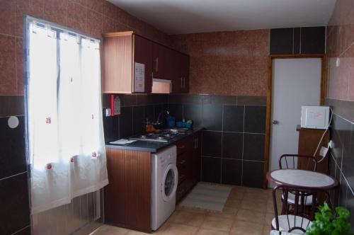 a small kitchen with a stove and a washing machine at Sao Jose Guesthouse in Ponta Delgada