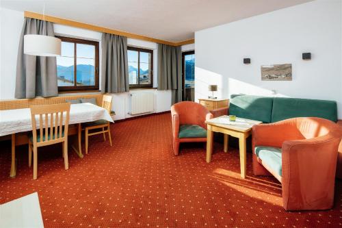 una habitación de hotel con mesa y sillas en Haus Kaschutnig, en Fiss