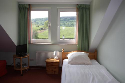 een slaapkamer met een bed en een raam met groene gordijnen bij Haus am Zeiberberg in Sinzig