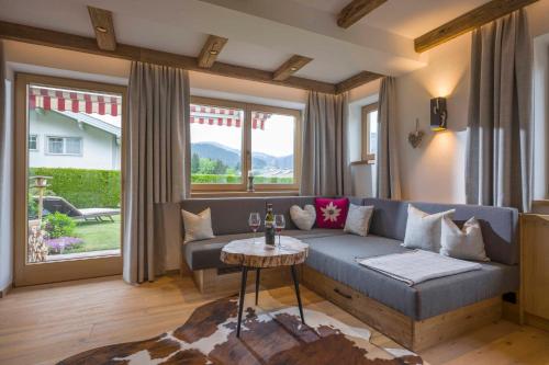 a living room with a couch and a table at Landhaus BergMoment - adults only in Ellmau