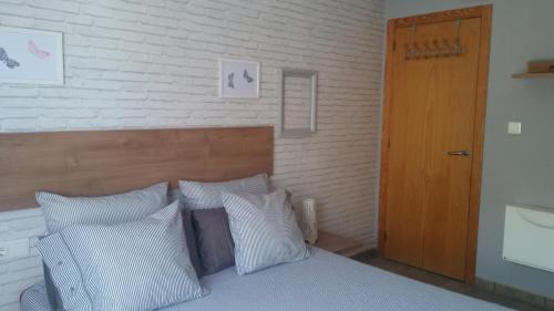 バレンシアにあるApartamento luminoso y acogedorのベッドルーム1室(白い枕と木製のドア付)