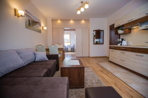 a living room with a couch and a kitchen at Savona Świnoujście in Świnoujście