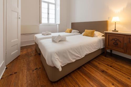 a bedroom with two beds and a wooden floor at Furadouro Surf Camp (House) in Ovar