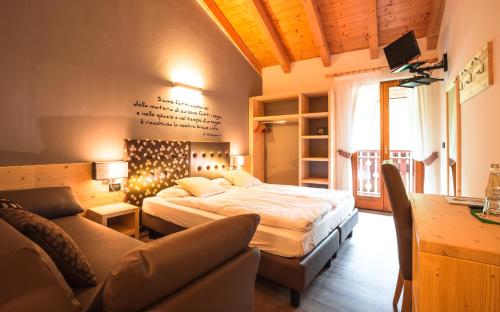 a bedroom with a bed and a couch at Albergo Maggiorina in Ledro