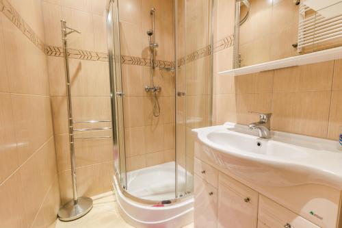een badkamer met een douche en een wastafel bij Pokoje Gościnne Mrągowo in Mrągowo