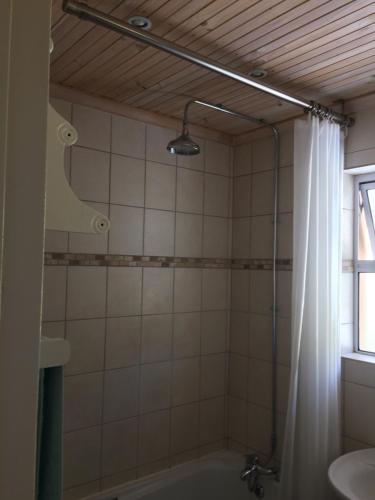 a bathroom with a shower and a tub and a sink at SIMONSBERG in Simonʼs Town