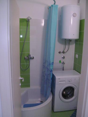 a bathroom with a washing machine and a washer at Seaview apartment in Omiš