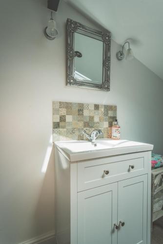 a bathroom with a white sink and a mirror at 40 Kirkgate in Thirsk