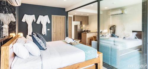 a bedroom with a bed and a glass wall at Rain Cha-am Huahin By Sake in Cha Am