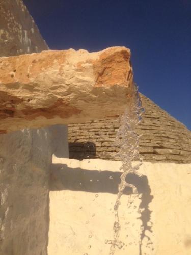 a building with a shadow on the side of it at Borgo trulli 1789 in Ostuni