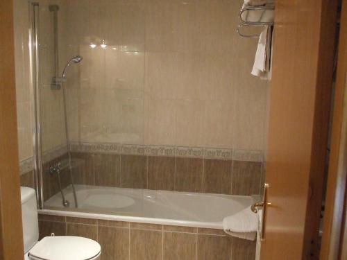 a bathroom with a bath tub and a toilet at Hostal Mont-Rock in Montagut