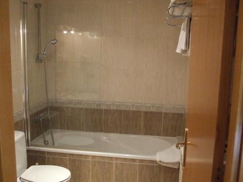 La salle de bains est pourvue d'une baignoire et de toilettes. dans l'établissement Hostal Mont-Rock, à Montagut