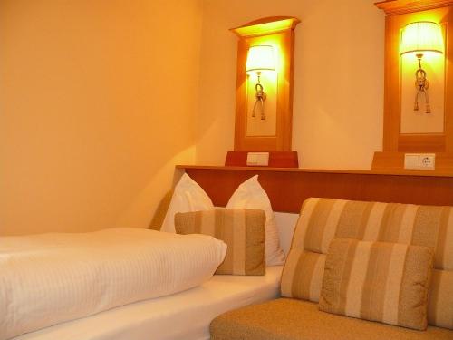 a hotel room with a bed and a chair at Gasthof-Pension zur Klause in Ratten