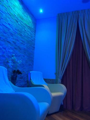 a room with blue lights and chairs in front of a brick wall at Hotel Villa Camilla in Varazze