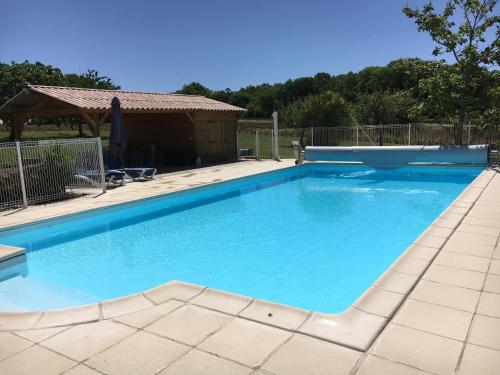 a swimming pool with blue water in a yard at Gîtes Oasis du Lot in Payrac