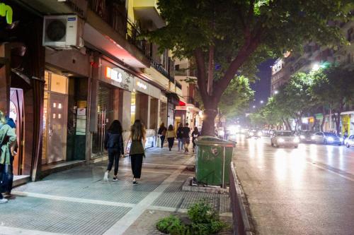 a group of people walking down a city street at night at Zen Luxury Living in Thessaloniki