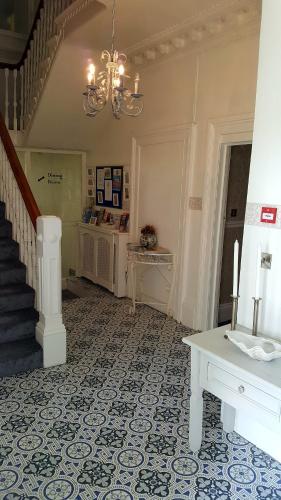 a living room with a staircase and a chandelier at The Sunfold in Weston-super-Mare