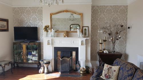 a living room with a fireplace and a mirror at The Sunfold in Weston-super-Mare