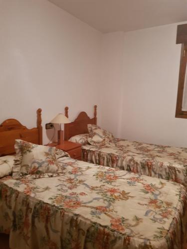a bedroom with two beds with a floral bedspread at Casa Simón in Roda de Isábena