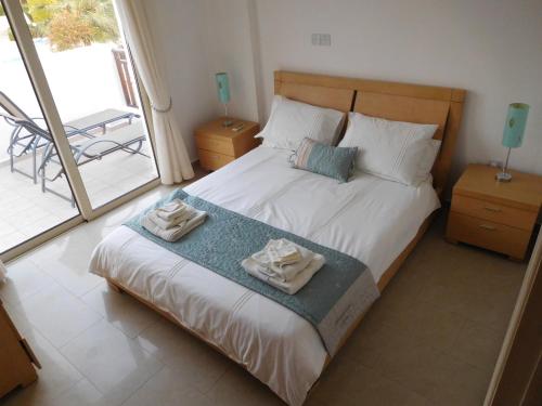 a bedroom with a bed with two towels on it at Vanessa 2 bedroom apartment in Paphos