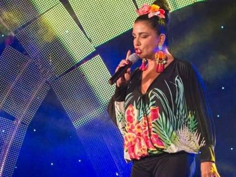 a woman singing into a microphone on a stage at Apartment Feral in Neum