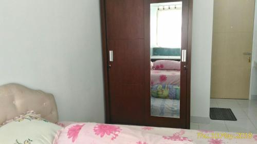 - une chambre avec un miroir et un lit dans une pièce dans l'établissement Apartment Kota Ayodhya - Christine, à Tangerang