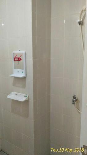 a bathroom with a shower with a box on the wall at Apartment Kota Ayodhya - Christine in Tangerang