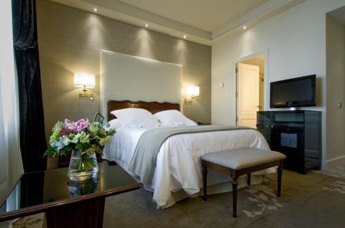 a bedroom with a bed and a vase of flowers on a table at Wellington Hotel & Spa Madrid in Madrid