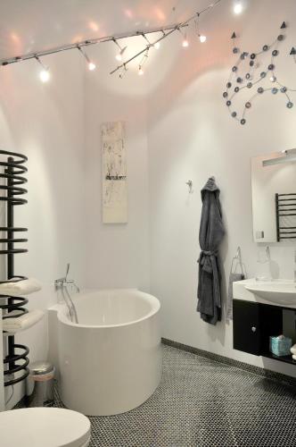 a white bathroom with a tub and a sink at South Lodge in Milton Keynes