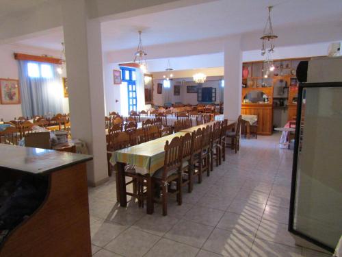una sala da pranzo con un lungo tavolo e sedie di Hotel Perissa a Perissa