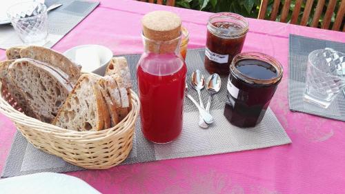 una mesa de picnic con una cesta de pan y mermelada en Résidence de Vaux, en Nans-sous-Sainte-Anne