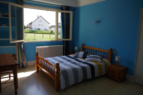 - une chambre avec un lit dans une pièce bleue dotée d'une fenêtre dans l'établissement Maison de famille Jo et Juliette, à Suin