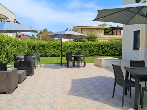 a patio with tables and chairs and umbrellas at Dimora Mariù in Taranto