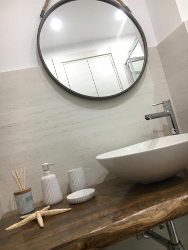 uma casa de banho com um lavatório e um espelho em Chez-Lu Ravello em Ravello