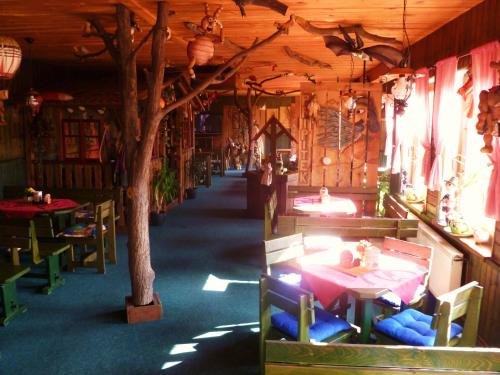 een restaurant met tafels en stoelen en een boom erin bij Hotel Pohádka in Most