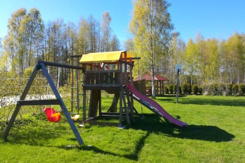 un parque infantil con tobogán en Beachside Guest House Strautini, en Plieņciems