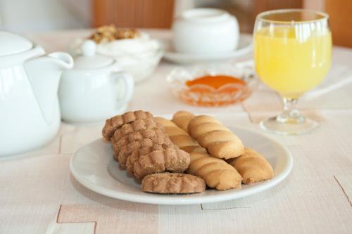 特尔斐Hermes Delphi Hotel的一小盘饼干和一杯橙汁