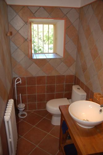 une salle de bain avec toilettes, lavabo et fenêtre dans l'établissement Mas de la Sauline, à La Roque-dʼAnthéron