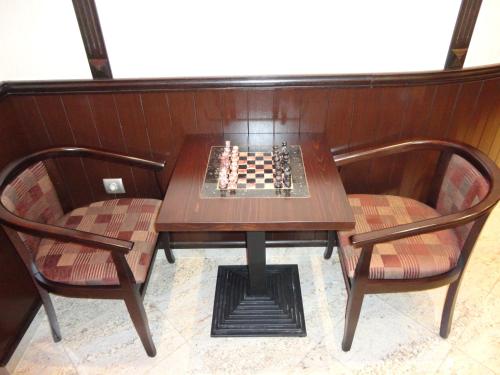 a table with a chessboard on it with two chairs at Favorit Hotel in Sofia