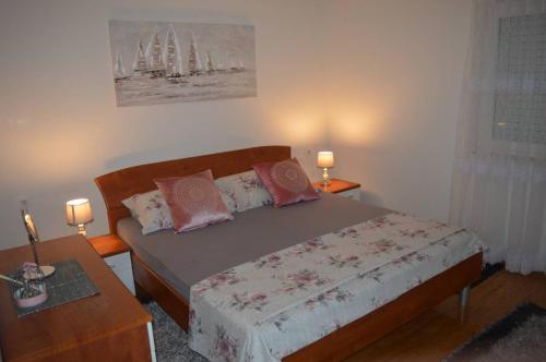 een slaapkamer met een bed met 2 tafels en 2 lampen bij Apartments Iva in Makarska
