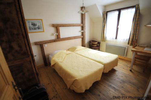 A bed or beds in a room at Auberge d'Anthy